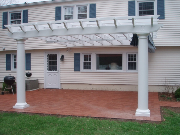 An attached fiberglass pergola with an overhead shade