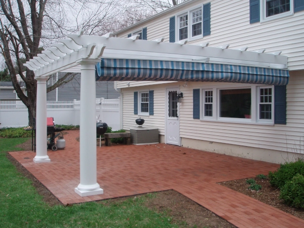 An attached fiberglass pergola with an overhead shade